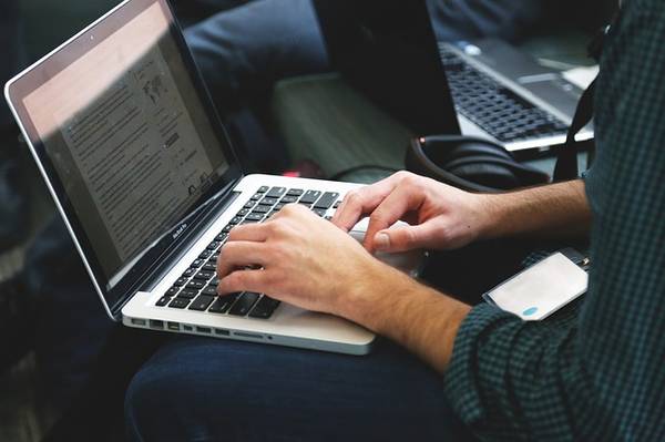 Person tippt auf Laptop